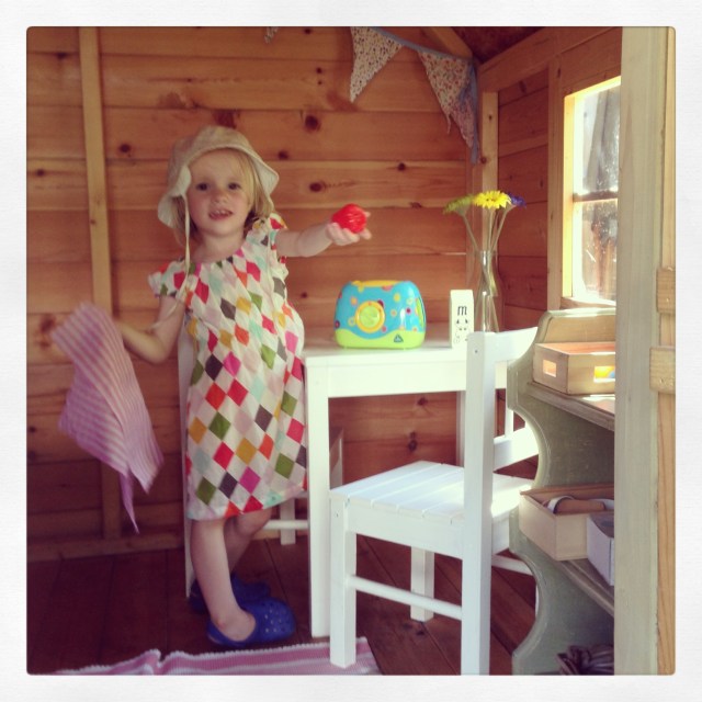 Seeking shade in the playhouse at the bottom of the garden